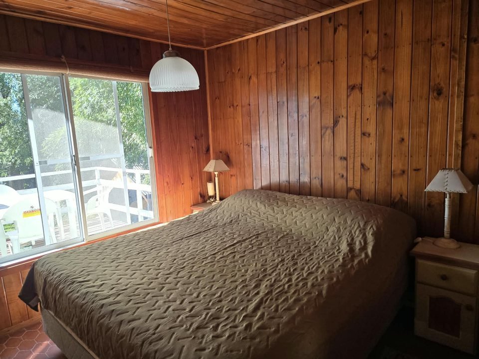 Dormitorio principal revestido en madera con cama king