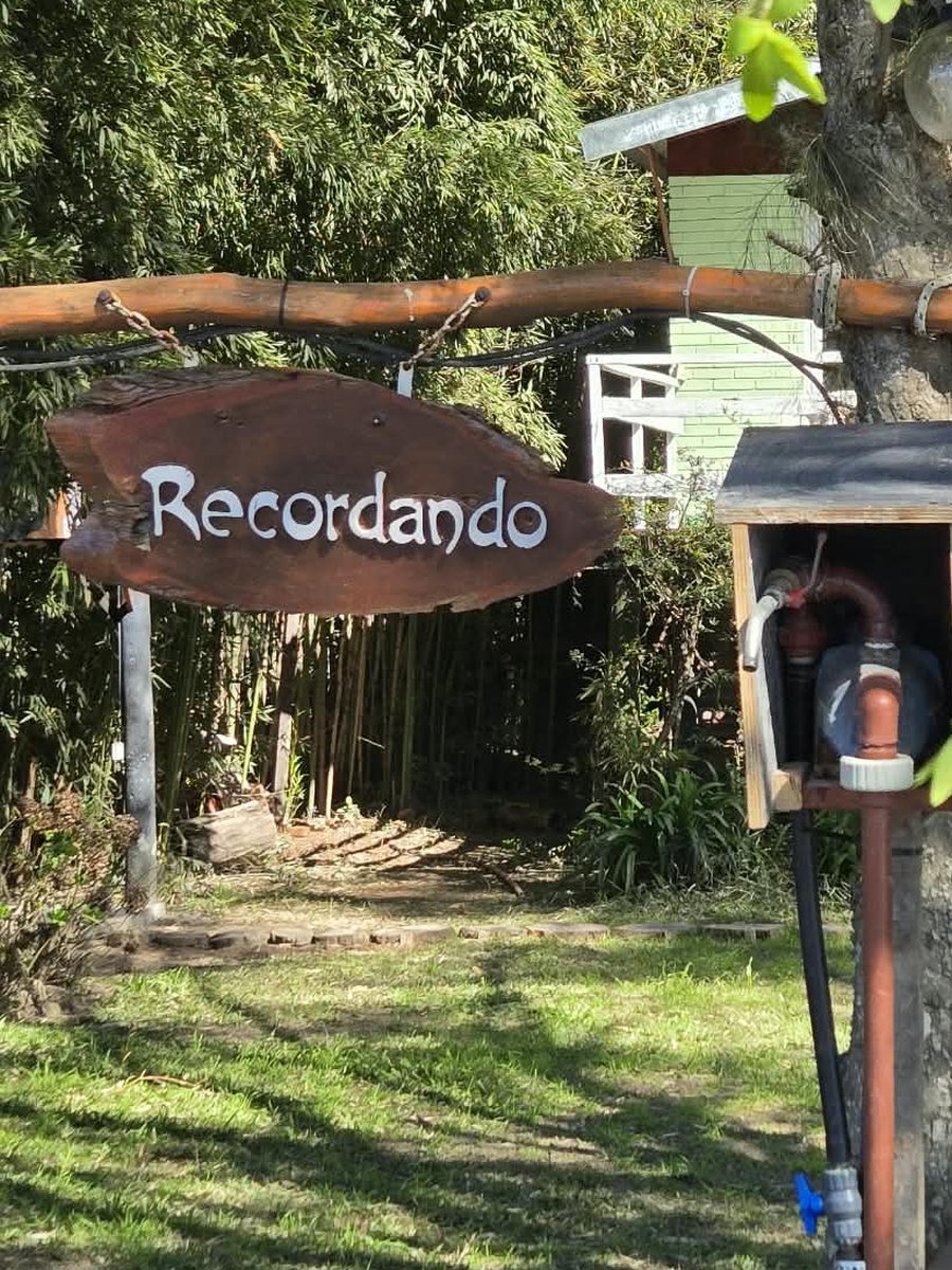 Cartel de madera con el nombre Recordando frente a la casa